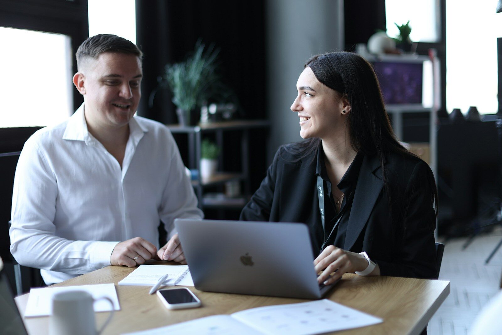Photo by Lyubomyr Reverchuk A man and a woman sitting at a table with a laptop